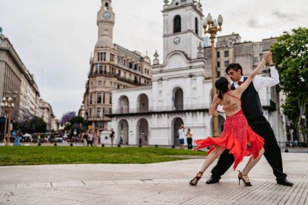 Young Latin couple dancing tango on Plaza de Mayo square in Buenos Aires, Argentina.